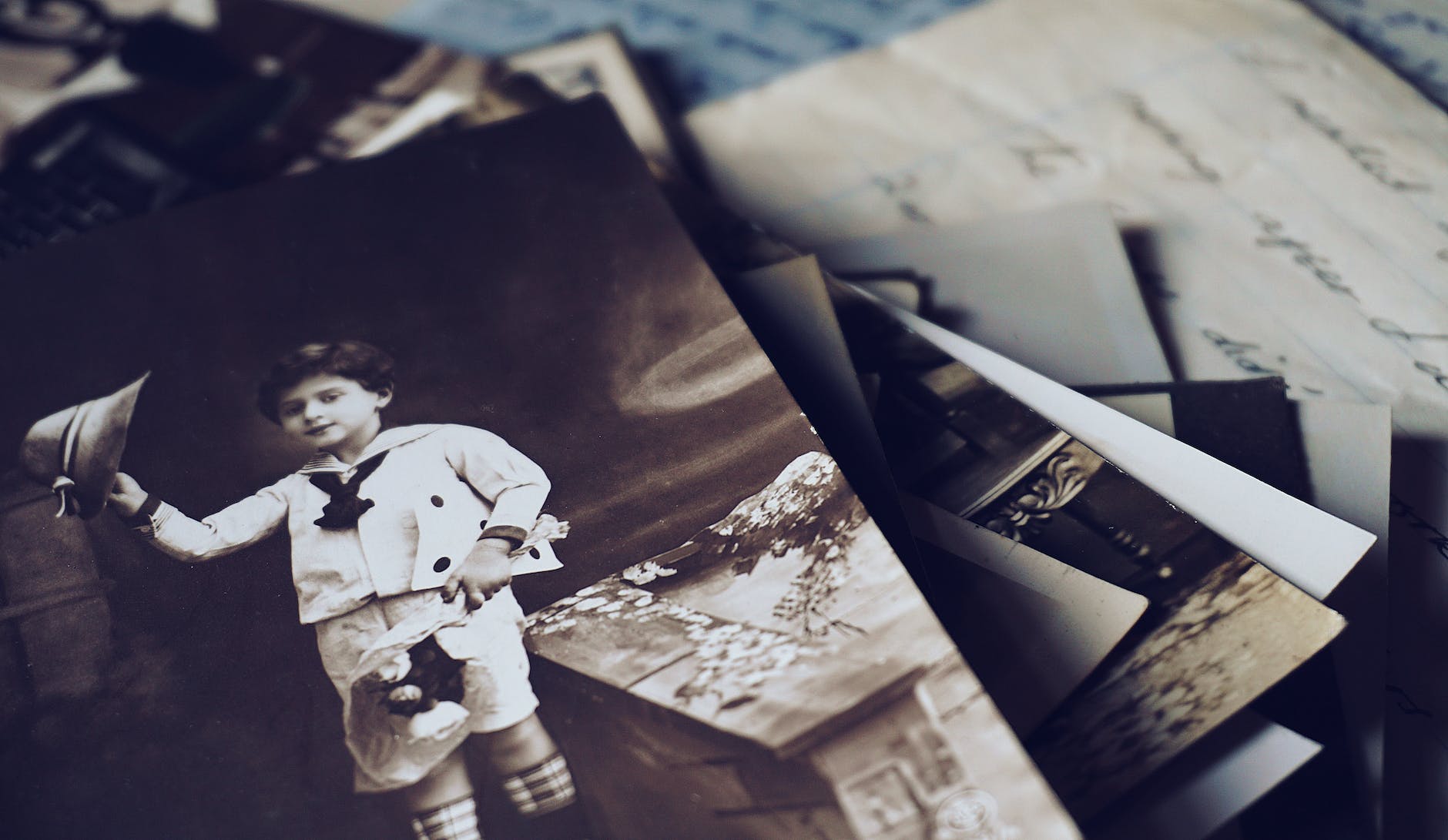 grayscale photo of boy holding hat